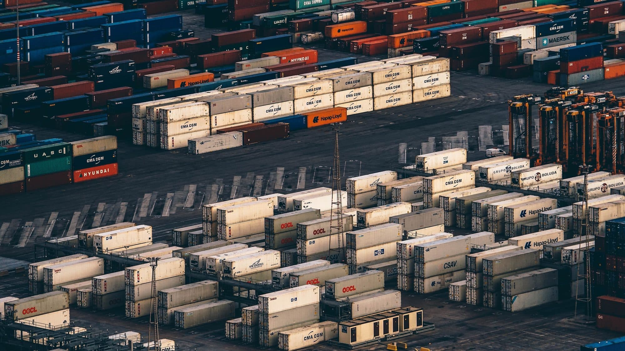 Gestapelte Schiffscontainer auf einem Hafengelände in der Abenddämmerung